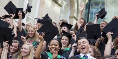 Nottingham Trent University students on graduation day, throwing their mortar-board hats in the air in celebration